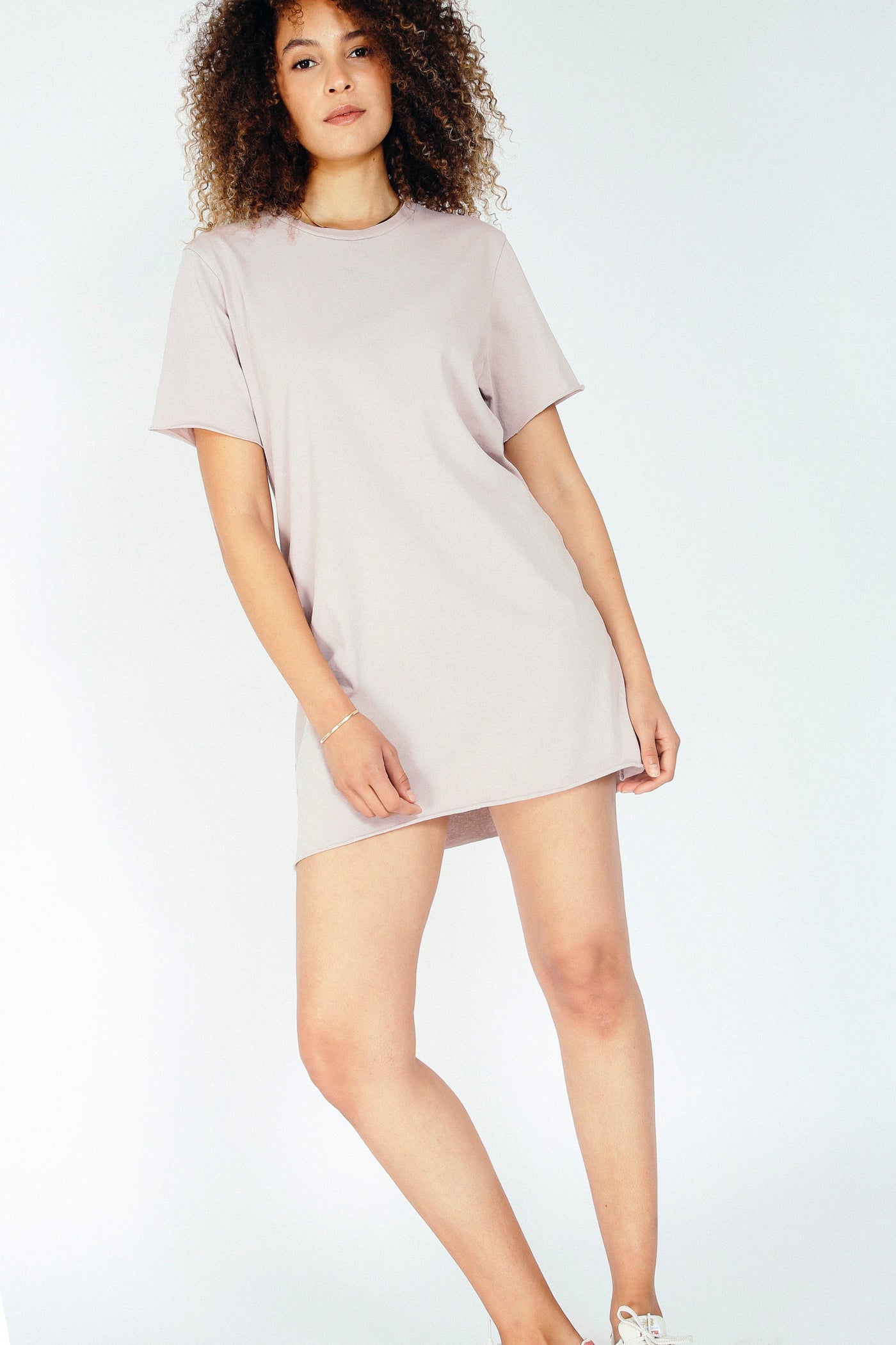 This super soft mini dress feels like a vintage concert tee. The perfect tee-shirt made into a dress with a raw hem and sleeve. Easy to wear, day to night, night to day. 100% crisp cotton. Many perfectly curated hues to choose from. Pictured in Mauve Mist.